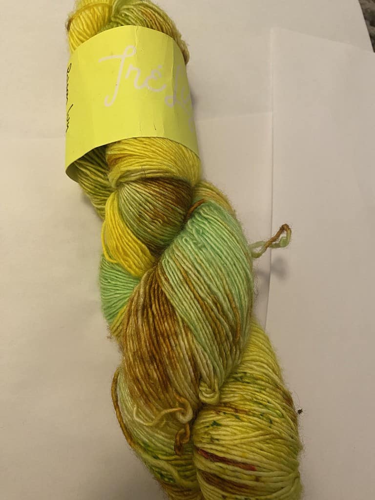 A skein of variegated hello, green and brown yarn.