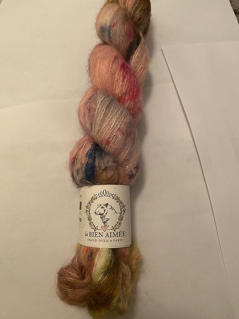 A skein of fuzzy pink, gray and orange and blue variegated yarn.