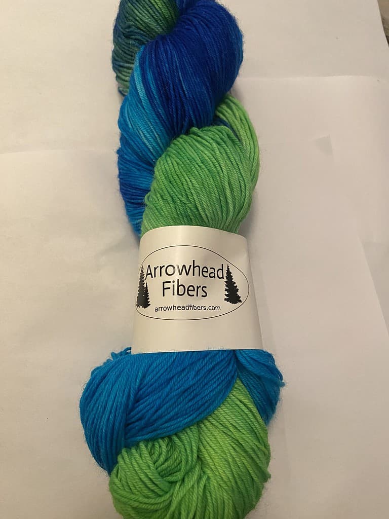 A skein of bright blue and green variegated yarn.