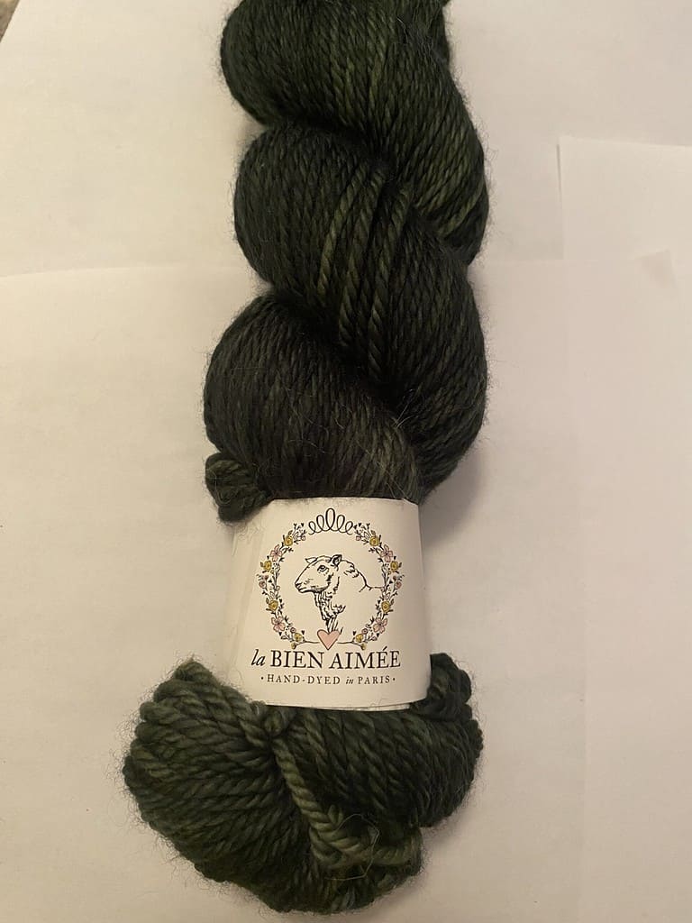 A skein of Aran weight dark green yarn.