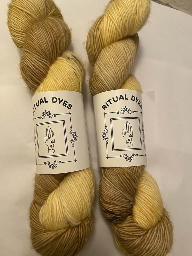 Two skeins of yellow and pea green yarn.