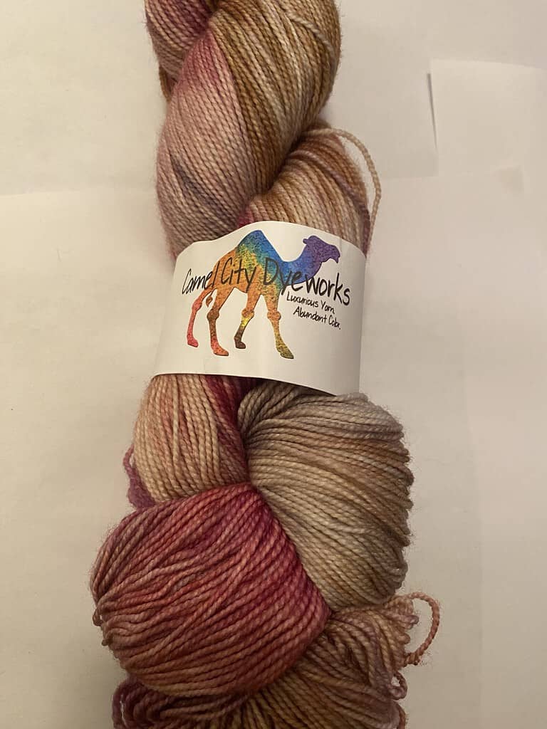 A skein of pink and gray variegated sock yarn.