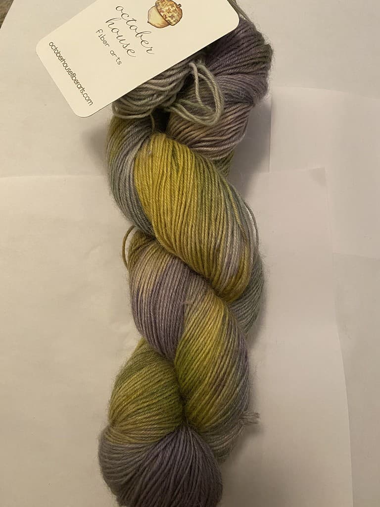A skein of gray and yellow variegated yarn.