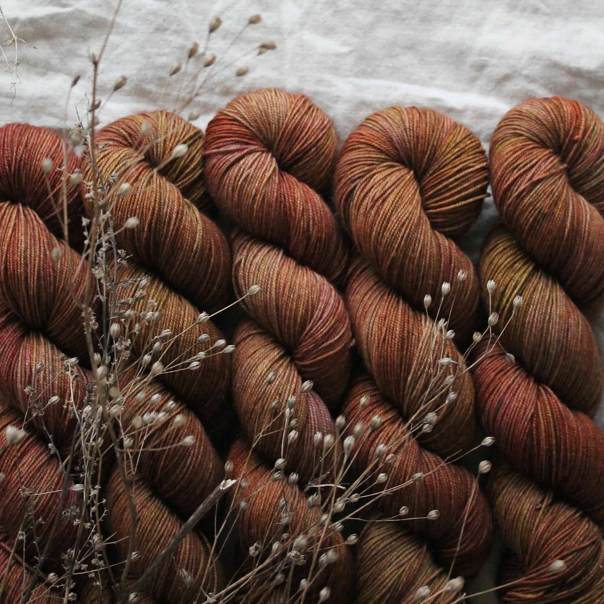 Skeins of brown yarn with small white flowers.