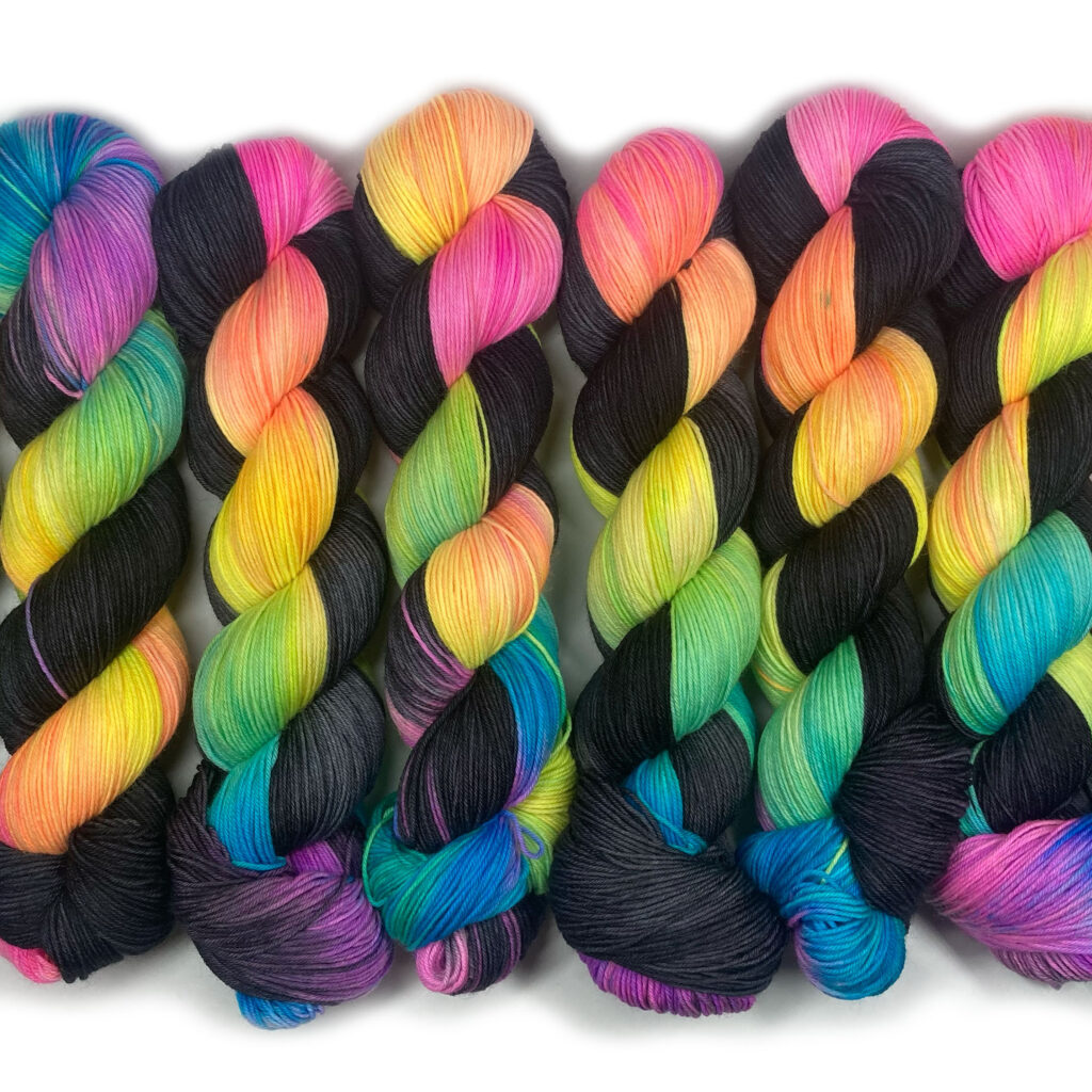 A skein of variegated black and rainbow yarn.