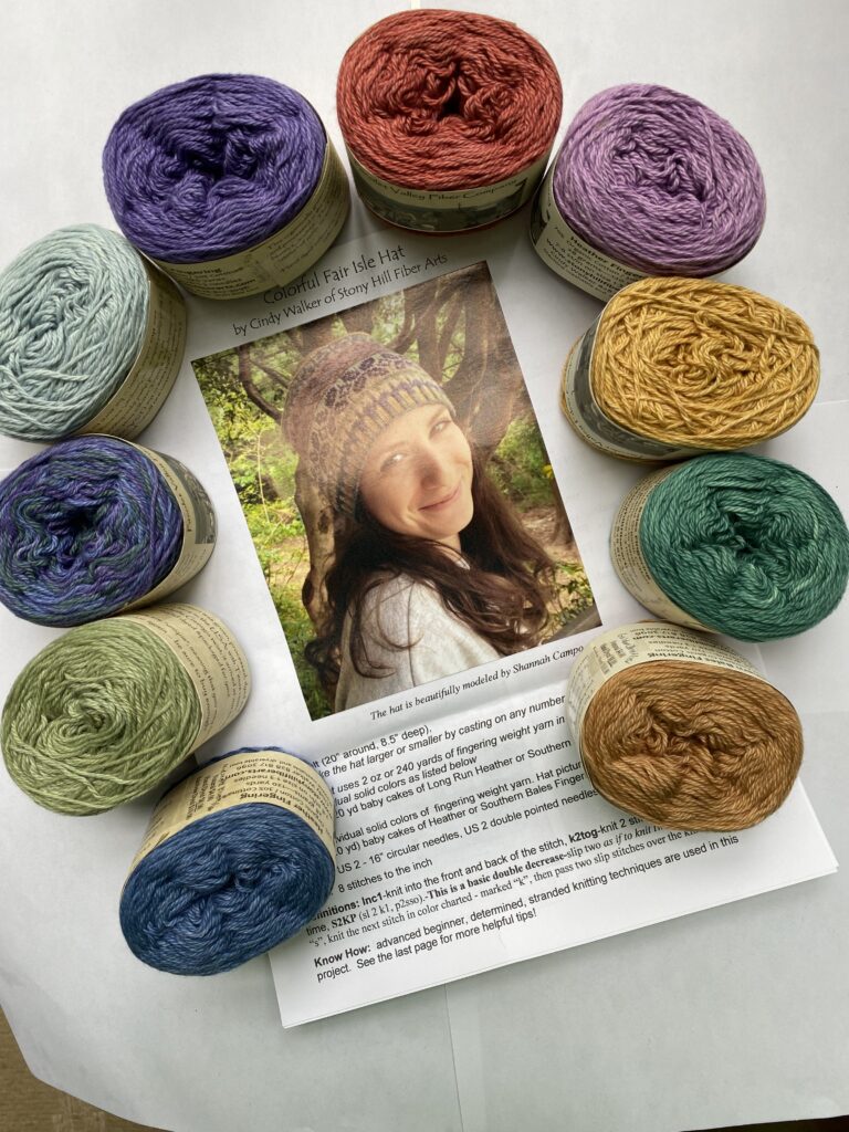 10 skeins of purple, blue, red, green and yellow yarn with hat pattern.