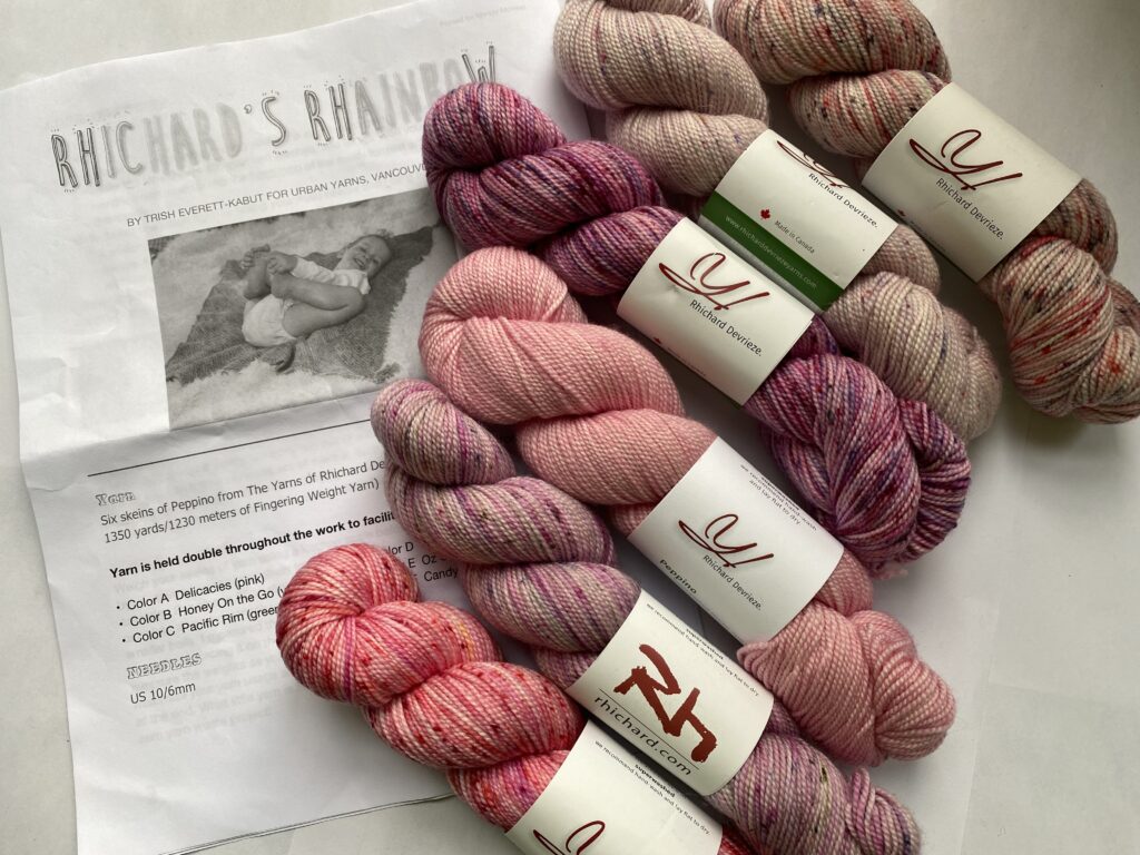 6 skeins of pink and purple yarn with baby blanket pattern.