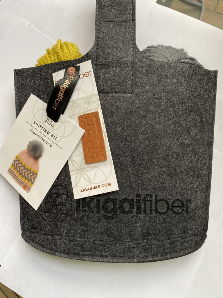 3 skeins yellow and gray yarn in black felt pouch with leather label.