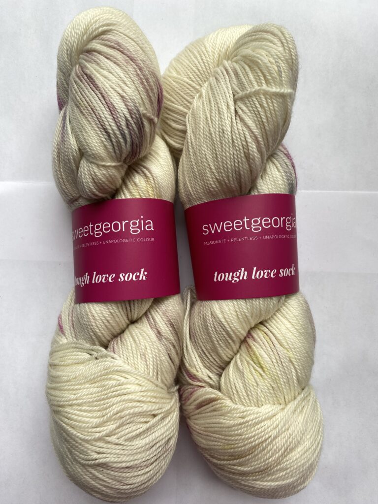 2 skeins of cream and pink yarn.