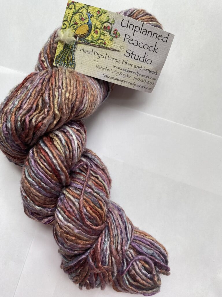 One skein of variegated pink, purple, rust and gray silk yarn.