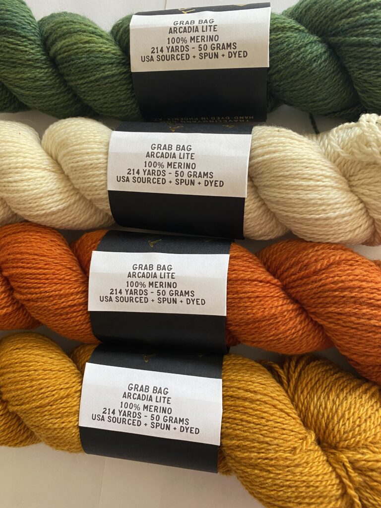 4 skeins of cream, dark green, dark orange and burnt yellow yarn.