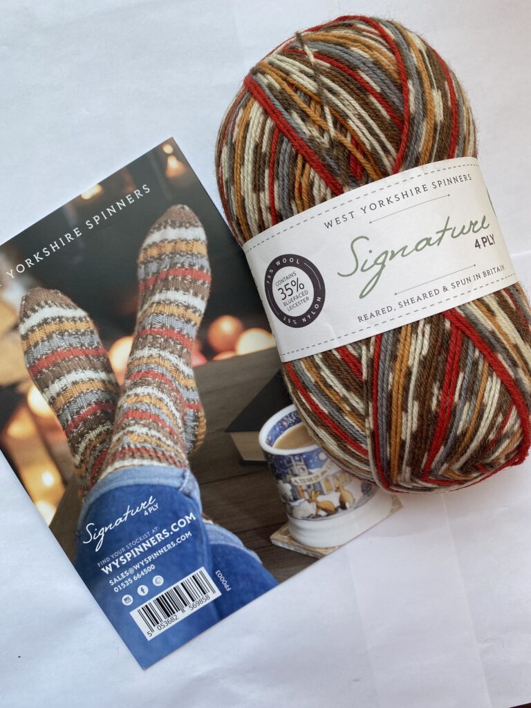 One skein self striping brown, cream, red, gray and yellow yarn with sock pattern.