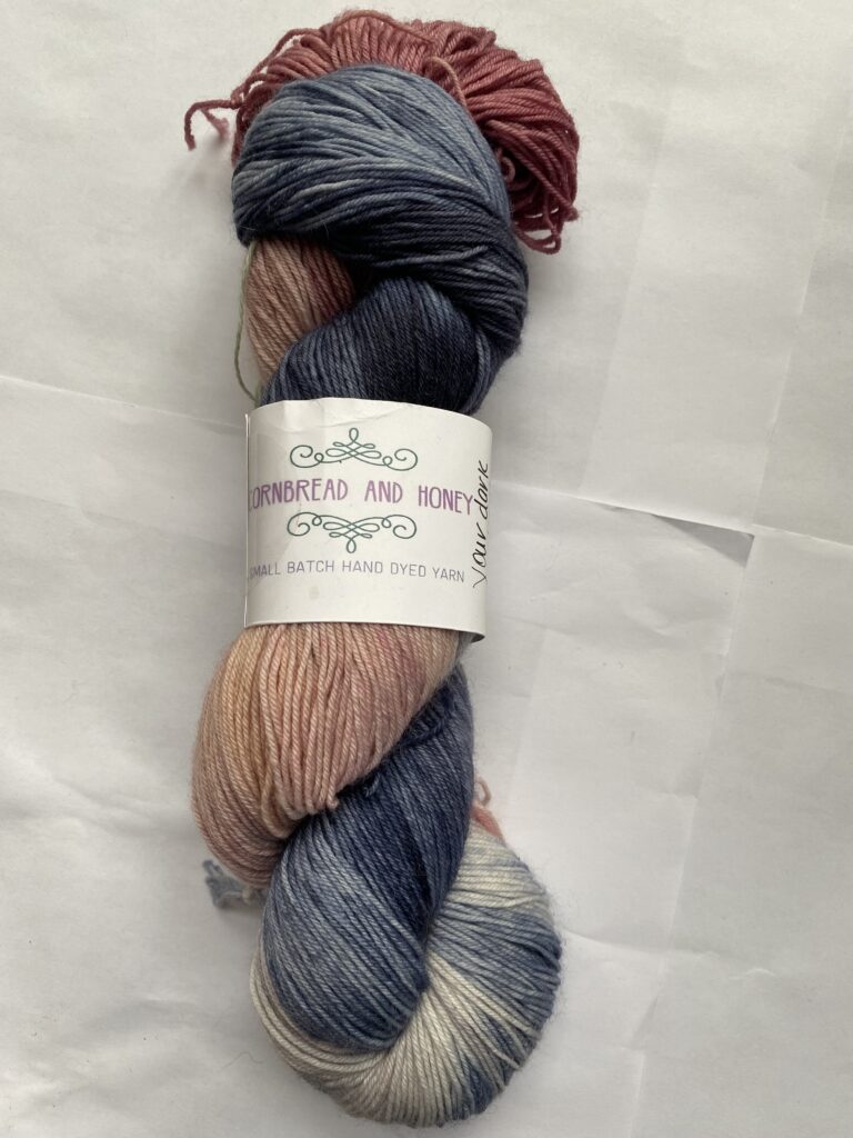 One skein of gray, blue and pink yarn.