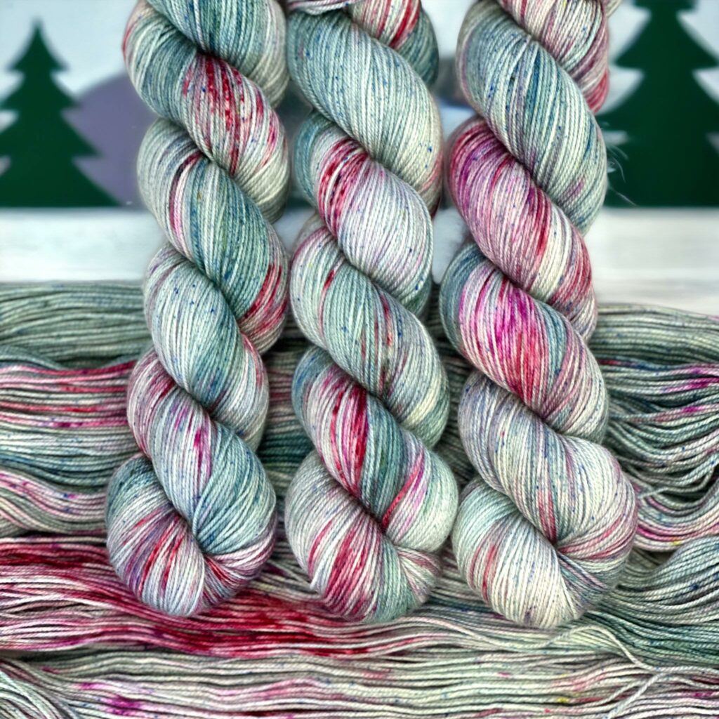 3 hanks of green and red and white speckled yarn.