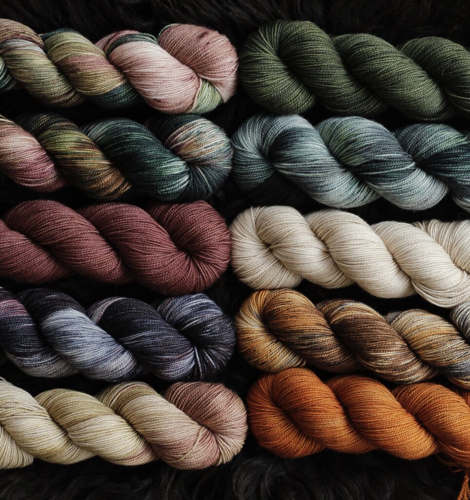 Ten different warm and cool toned autumnal colored yarns.