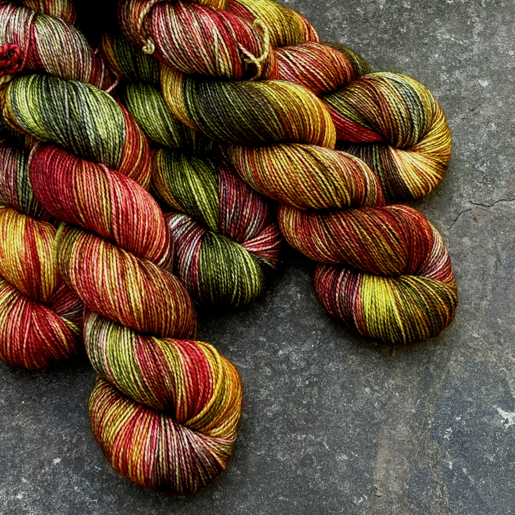 Five skeins of bright red, orange, green and yellow fall colors on sock yarn.