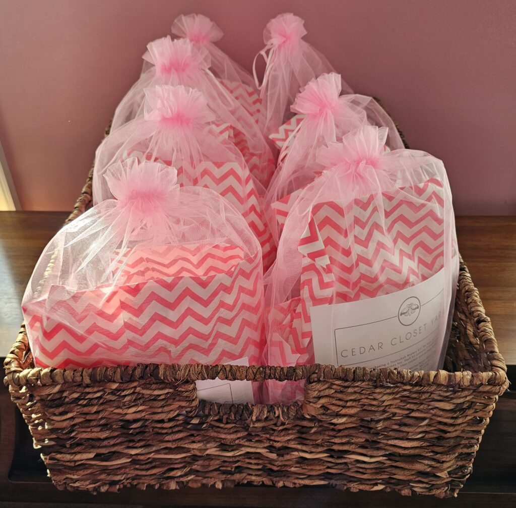 Pink organza bags with a pink and white chevron pattern inside, arranged in a rectangular basket.