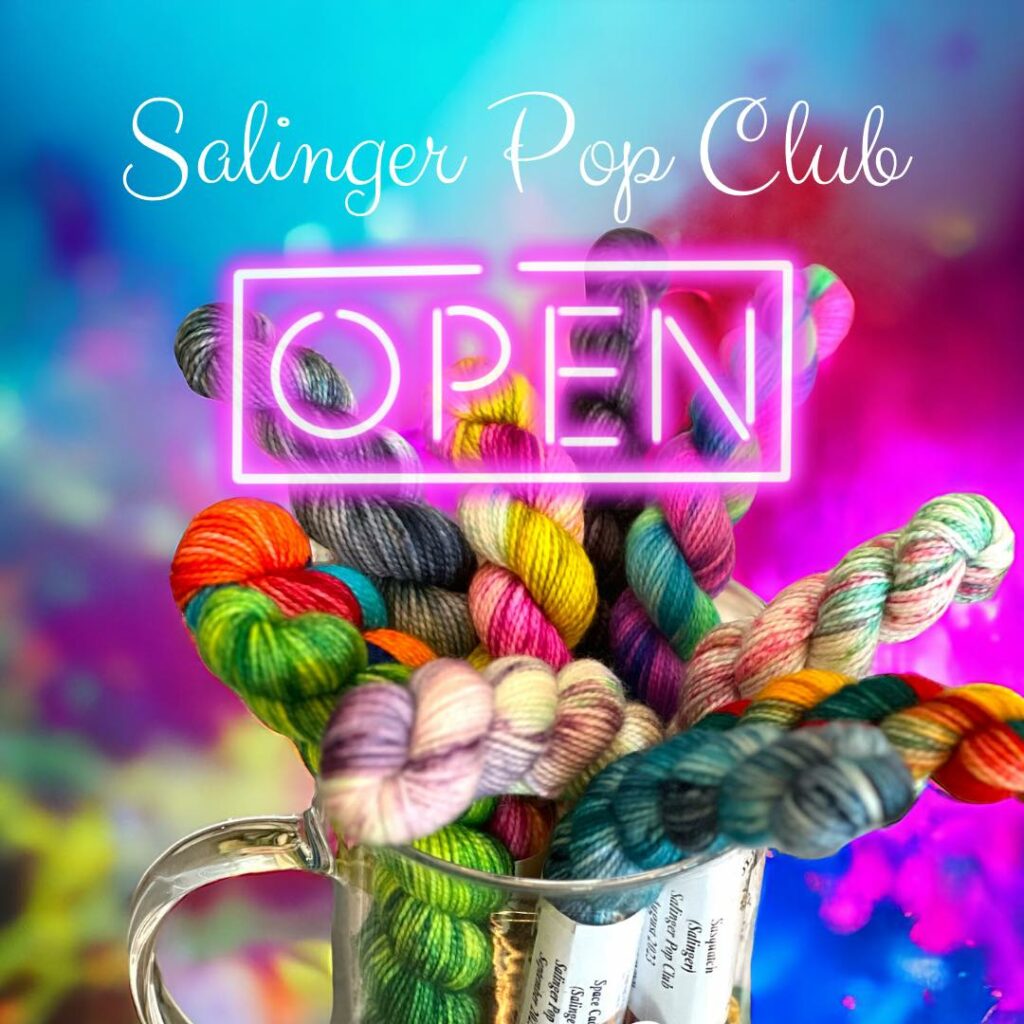 A colorful assortment of mini skeins of yarn in a clear mug and the text Salinger Pop Club Open.