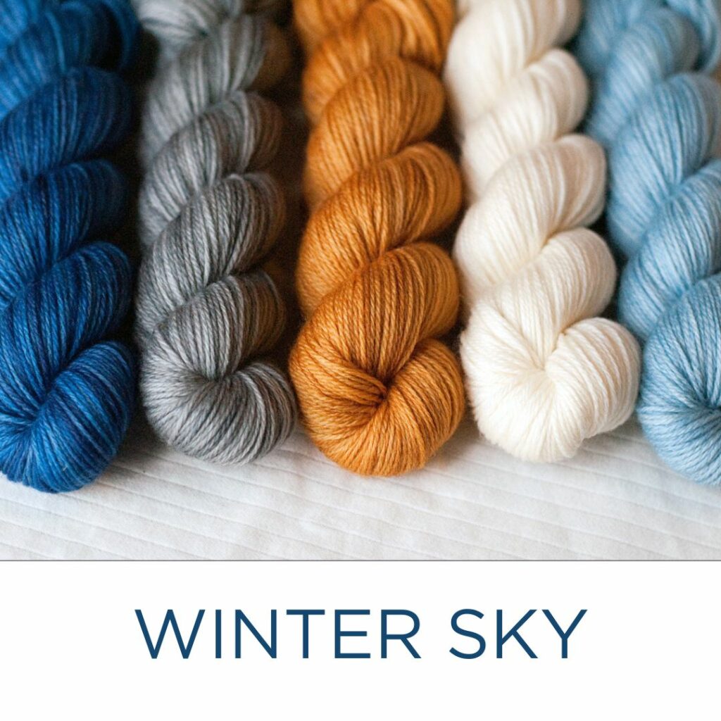 The "Winter Sky" set of mini-skeins in dark blue, medium grey, golden yellow, natural white, light blue.