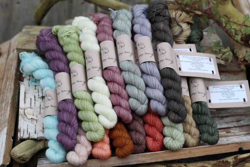 A pile of mini skeins of yarn in several colours.