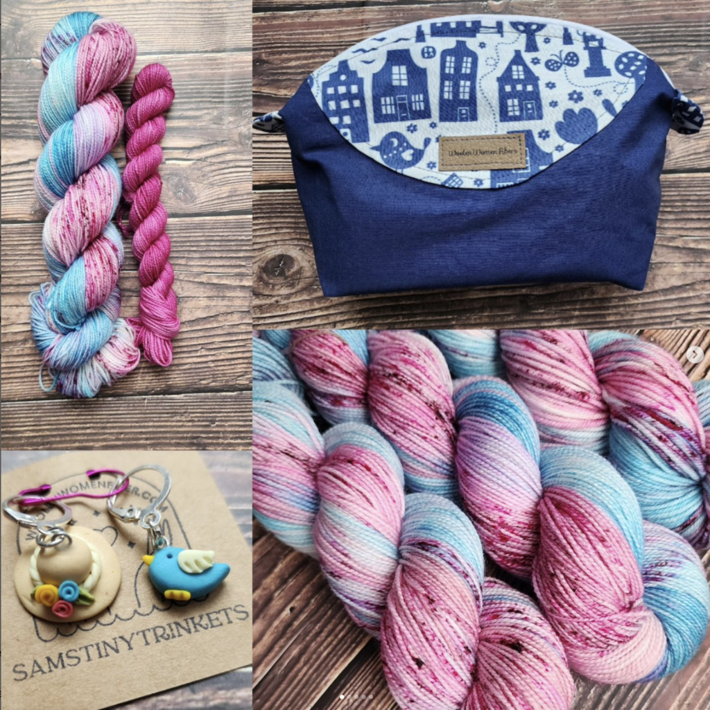 Blue sky yarn with cherry blossom speckles, a navy blue bag accented with small town spring blue and white fabric and a set of stitch markers, a spring hat and blue bird.