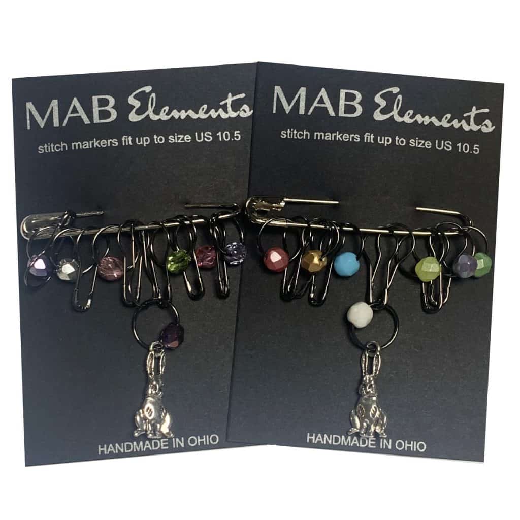 Silver bunny stitch markers with multicolored beads and a black card.