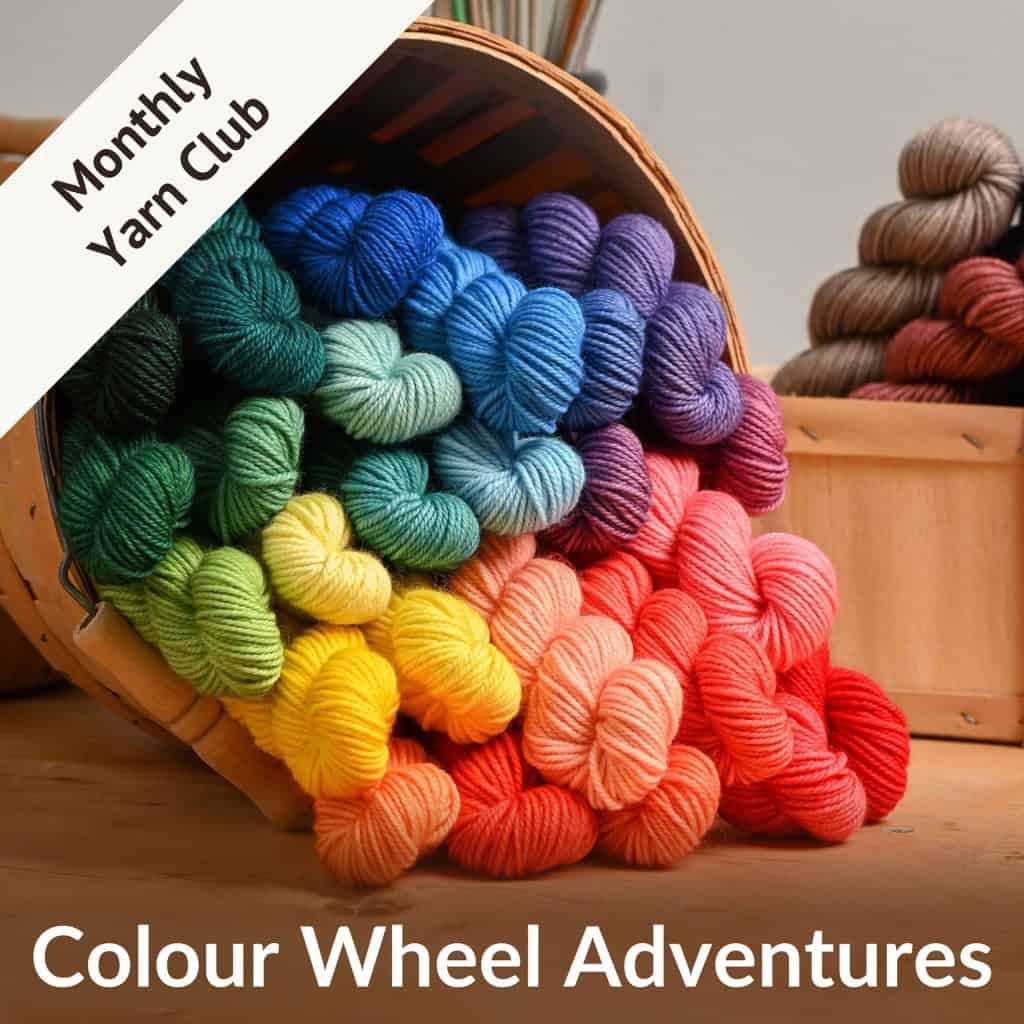 A basket full of colourful mini skeins of yarn, text reading colour wheel adventures - monthly yarn club.