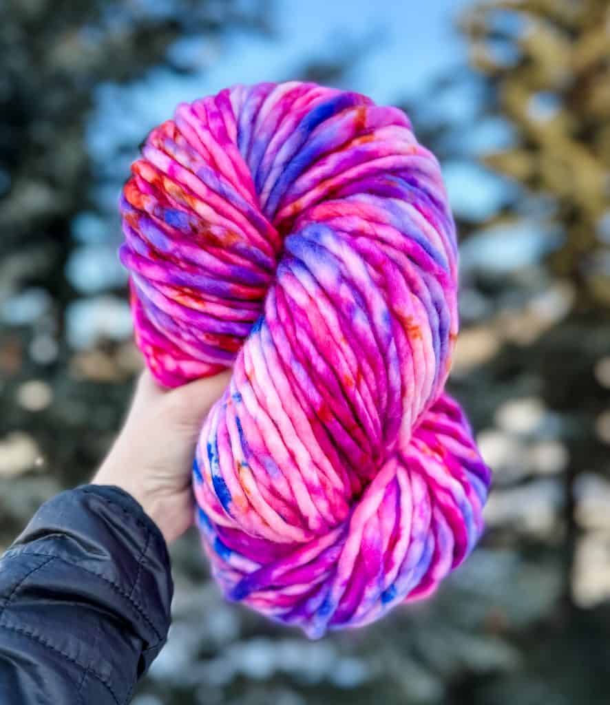 A vibrant skein of pink and blue yarn.