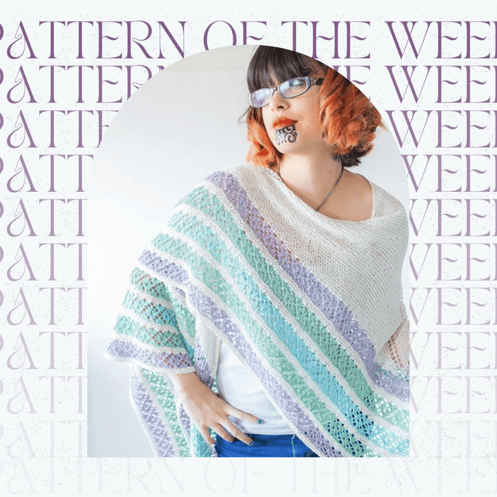 A white shawl with green, blue and purple lace stripes draped over the shoulders of a woman. Pattern of the week is repeated in the background.
