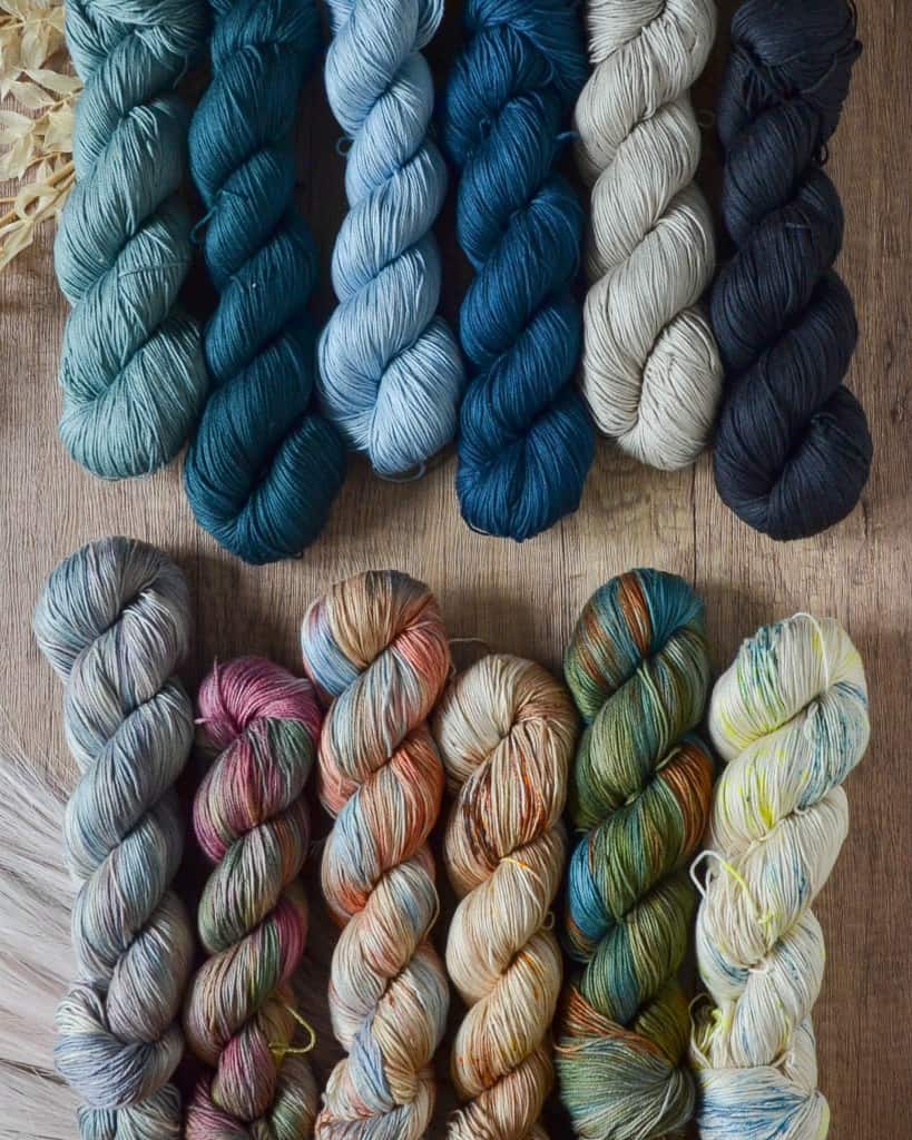 A flat lay of 12 cotton tencel yarns in a palette of coastal colors.