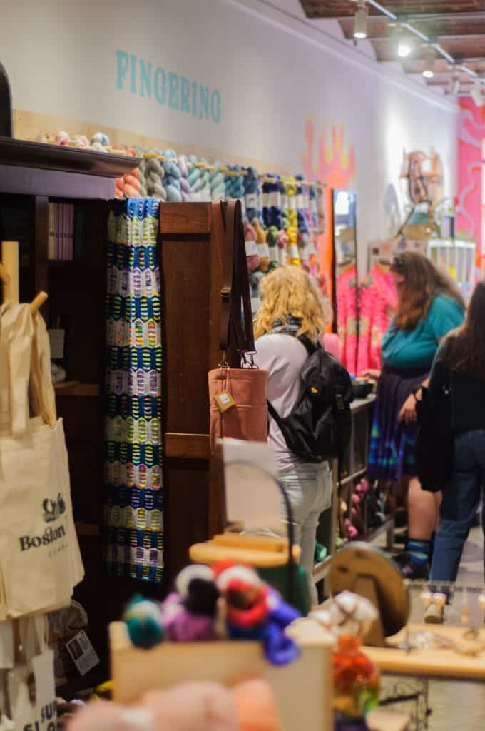 Shoppers browsing yarn inside a store.