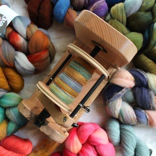 E-spinner surrounded by multiple colors of combed top and yarn