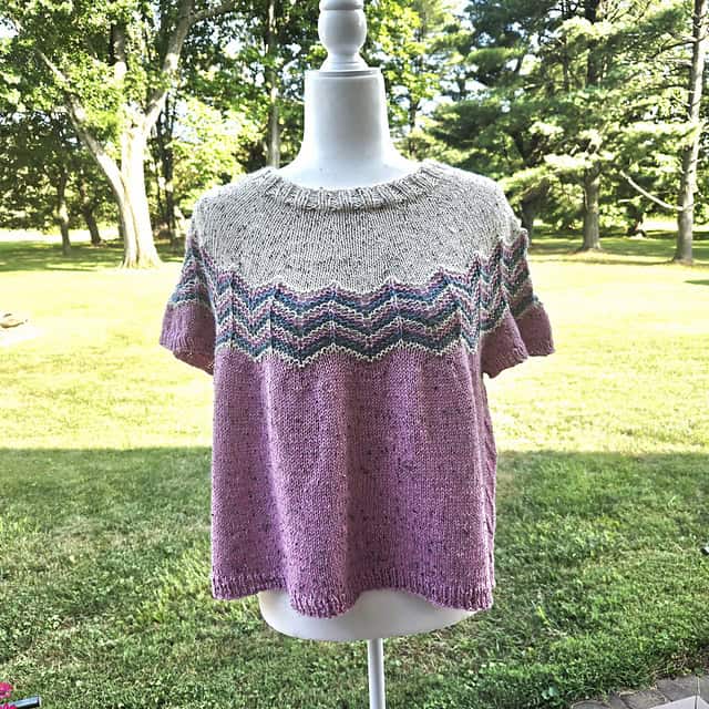 knitted top on shirt mannequin outside in the colors grey and pink