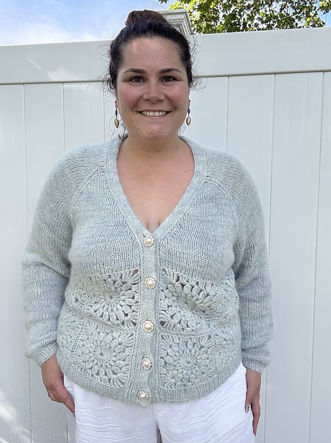 Light skinned woman wearing knitted light blue green cardigan