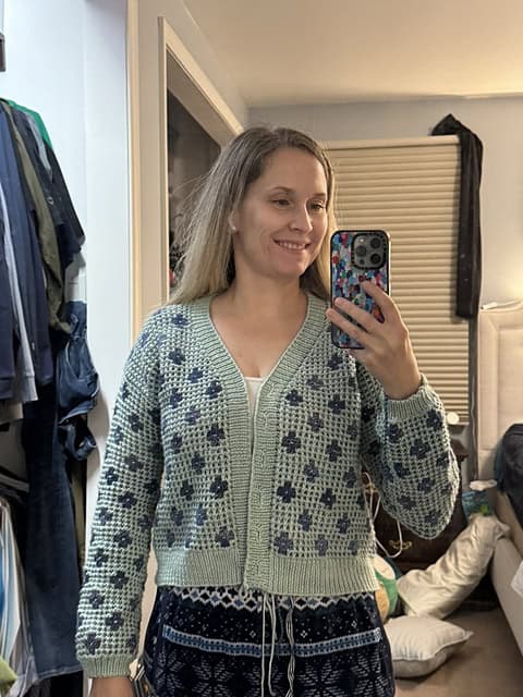 Light skinned woman wearing knitted sage green cardigan