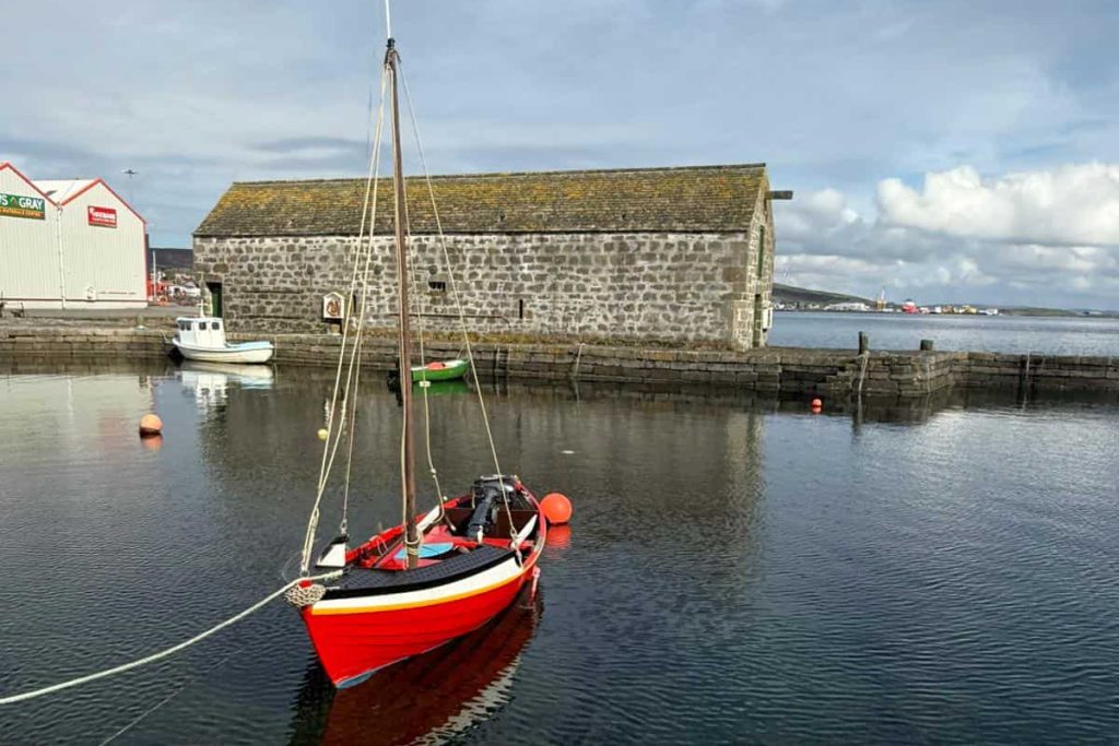 red boat tied up to dock