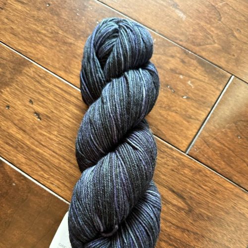 A skein of a dark blue-navy worsted weight yarn.