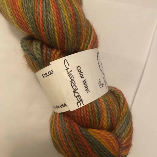 A skein of multi-color yarn in fall colors of yellow, orange, green and brown.