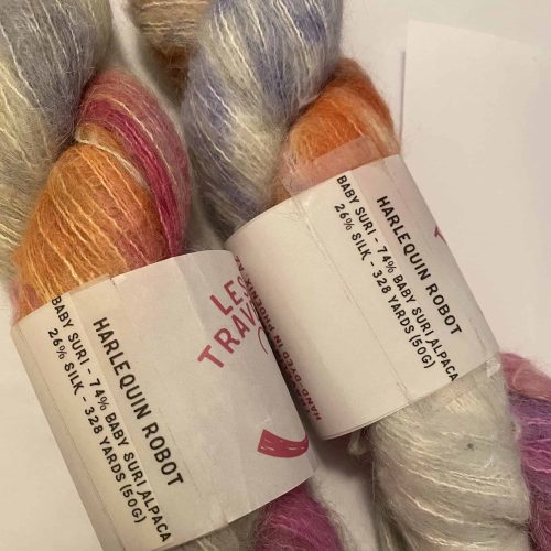 Two skeins of fuzzy purple, gray and orange variegated yarn.