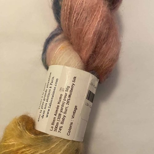 A skein of fuzzy pink, gray and orange and blue variegated yarn.
