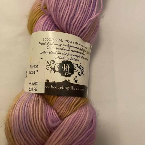 A skein of purple and yellow variegated single-ply yarn.