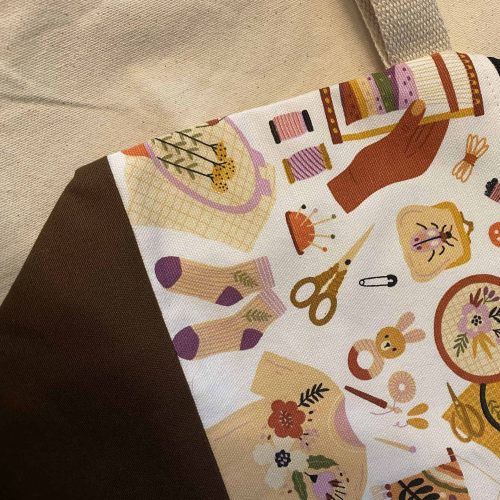 Zippered project bag with knitting images.