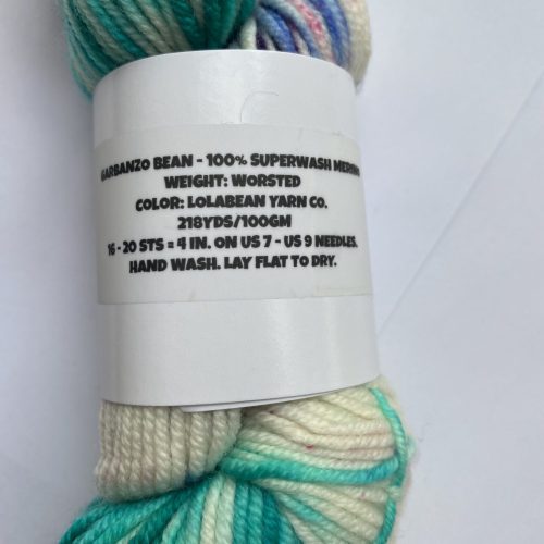 One skein variegated and speckled yarn in neutral, aqua and purple.