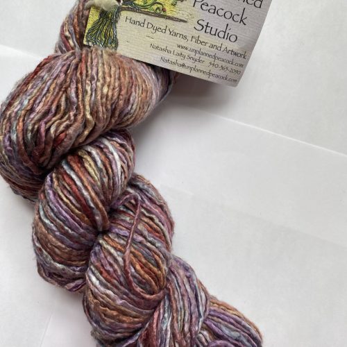One skein of variegated pink, purple, rust and gray silk yarn.