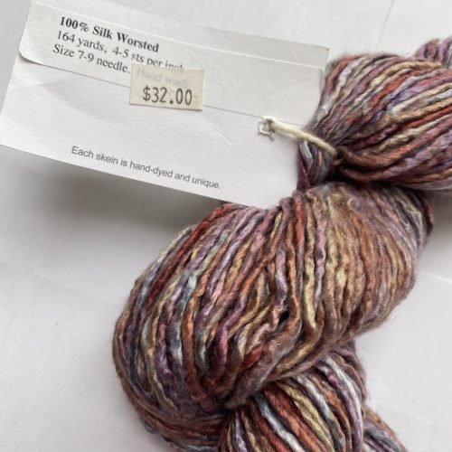 One skein of variegated pink, purple, rust and gray silk yarn.