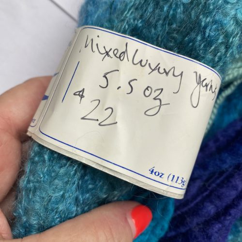 Yarn bundle from spinning fiber to spun yarn in aqua and purples.