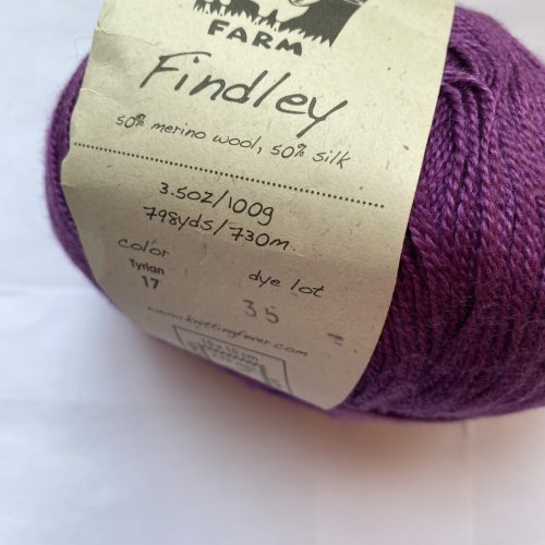 Closeup of a label on a ball of purple yarn.