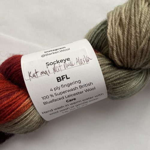 One skein of gray, burgundy, purple and pink yarn.