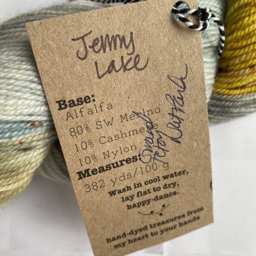 Close-up of the tag on a skein of blue green, brown and yellow yarn.