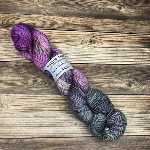 A skein of variegated yarn in purples and greys.